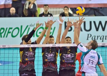File önünde blok yapan erkek voleybol oyuncuları ve top.
