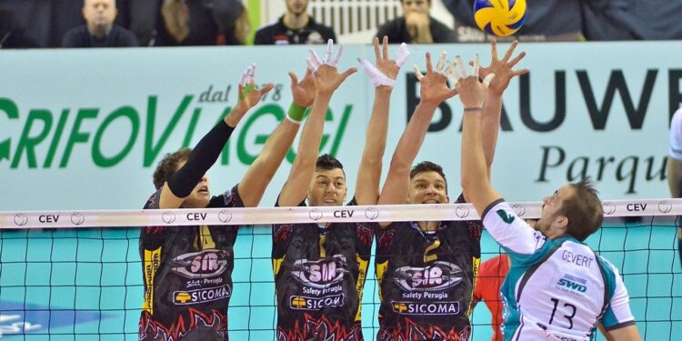 File önünde blok yapan erkek voleybol oyuncuları ve top.