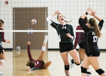 Siyah formalı voleybolcu kızlar file önünde sevinç çığlığı atıyor