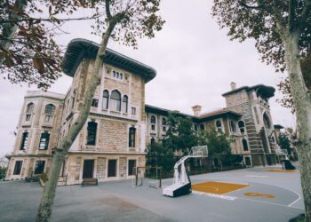 Tarihi bir okul binasının bahçesinde bulunan basketbol sahası.