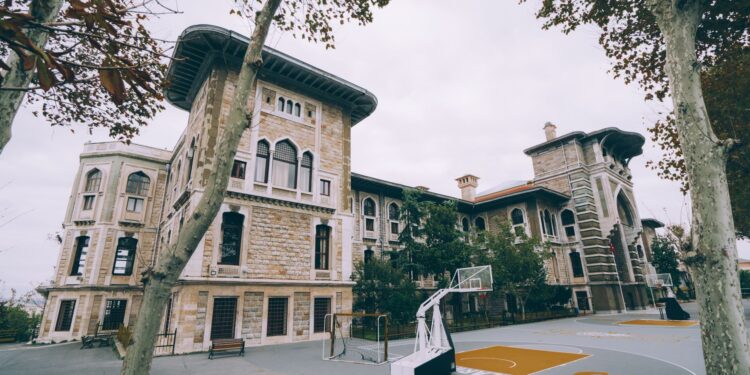 Tarihi bir okul binasının bahçesinde bulunan basketbol sahası.