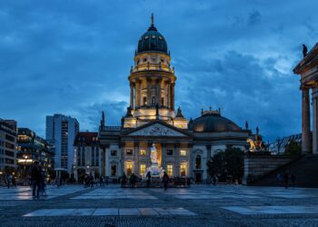 Akşam karanlığında Berlin'deki Gendarmenmarkt meydanı ve tarihi yapıların aydınlatılmış görünümü.
