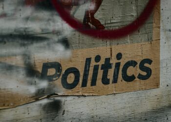 Üzerinde 'Politics' yazan, eskimiş ve yıpranmış bir sokak afişi.