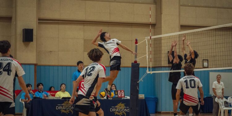 Salon voleybolu maçında file önünde yükselerek smaç vuran oyuncu.
