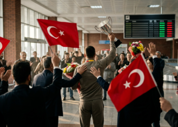 Kastamonu Havalimanı'nda Türk bayrakları eşliğinde kupa kaldıran şampiyon sporcunun coşkulu karşılanma anı.