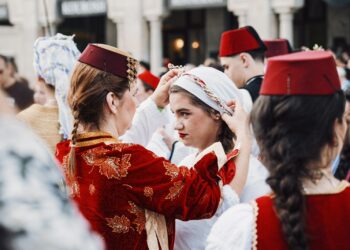 Geleneksel kıyafetler giymiş kadınlar başlık düzenliyor ve festival atmosferi yaratıyor.