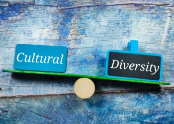 Ahşap terazi üzerinde Cultural ve Diversity yazan mavi tabelalar duruyor.