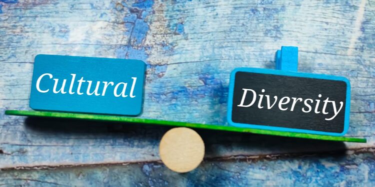 Ahşap terazi üzerinde Cultural ve Diversity yazan mavi tabelalar duruyor.