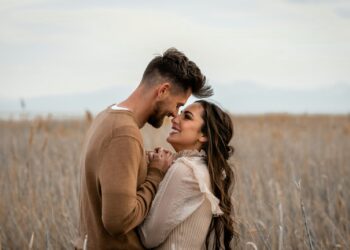 Açık havada birbirine sarılıp gülümseyen romantik genç bir çift.